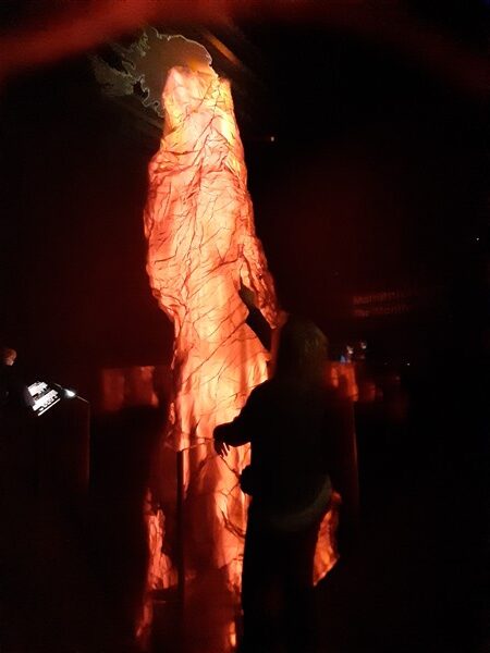 Vrouw bekijkt een model van een magmatunnel onder IJsland