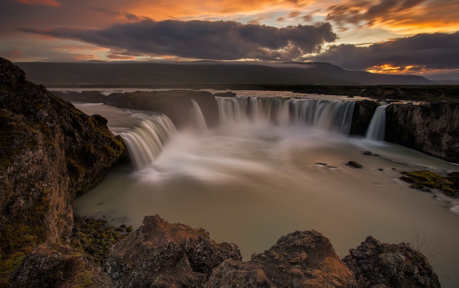 waterval en bergen en zonsondergang