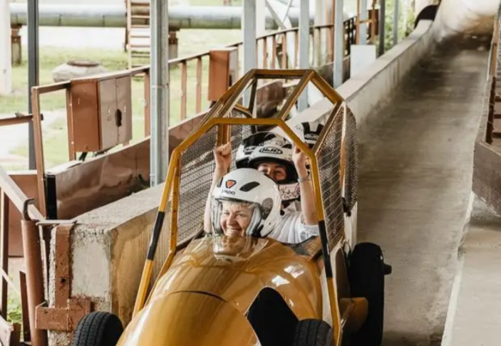 2 mensen in een bobslee op wielen