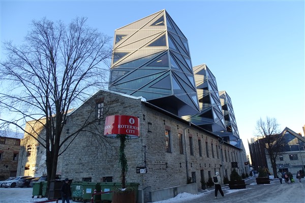 Modern glazen gebouw bovenop een historisch stenen pand in het Rotermann Kwartier, Tallinn.