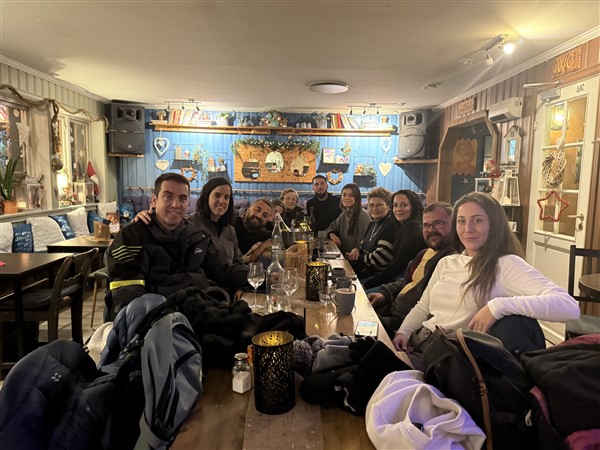 Een gezelschap aan een tafel in een gezellig restaurant