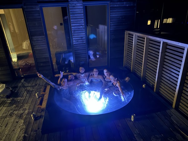 Mensen in een jacuzzi 's avonds buiten met mooie verlichting