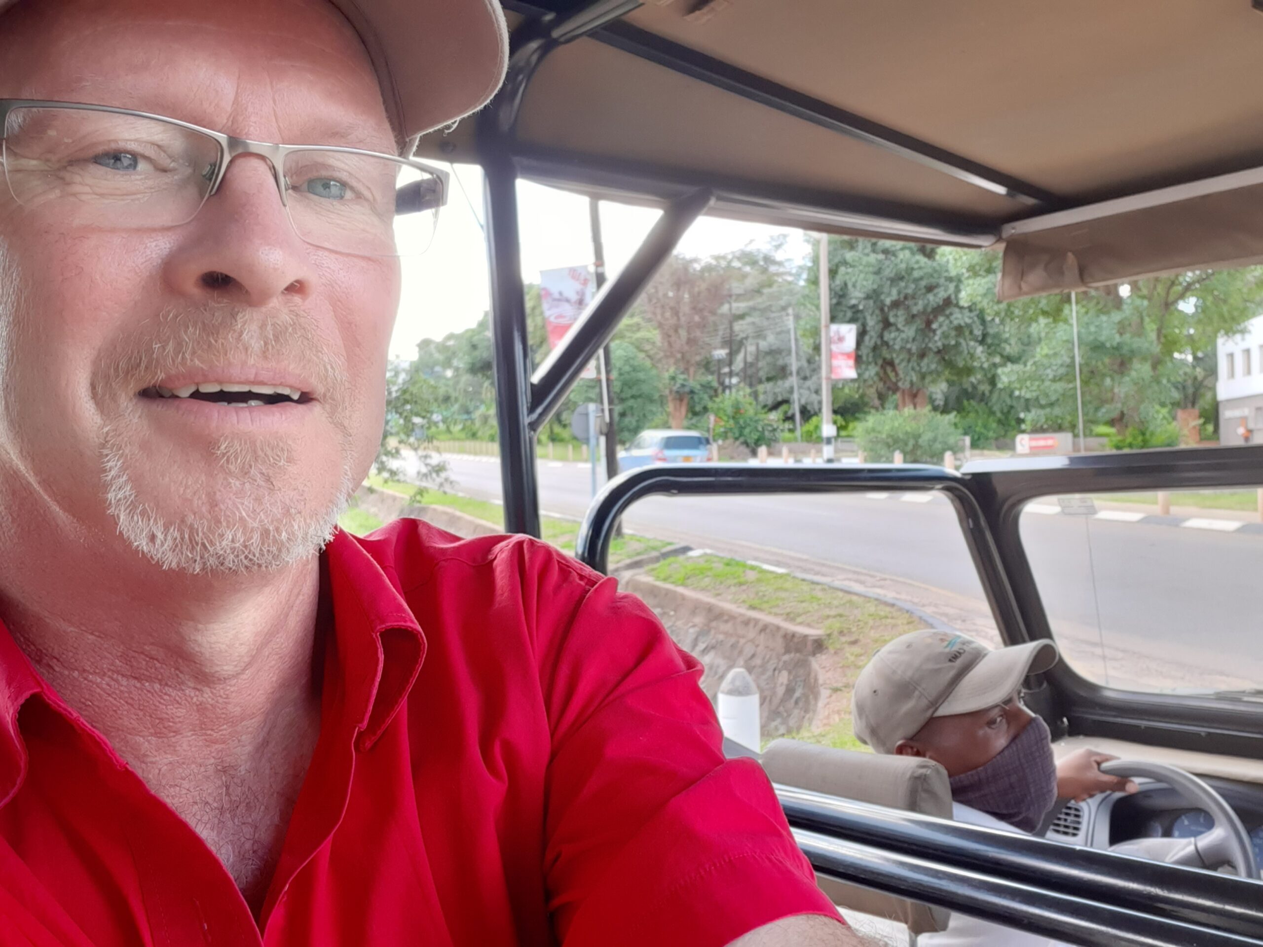 Passagier maakt een foto van de chauffeur en de omgeving tijdns een taxi transfer in Victoria Falls