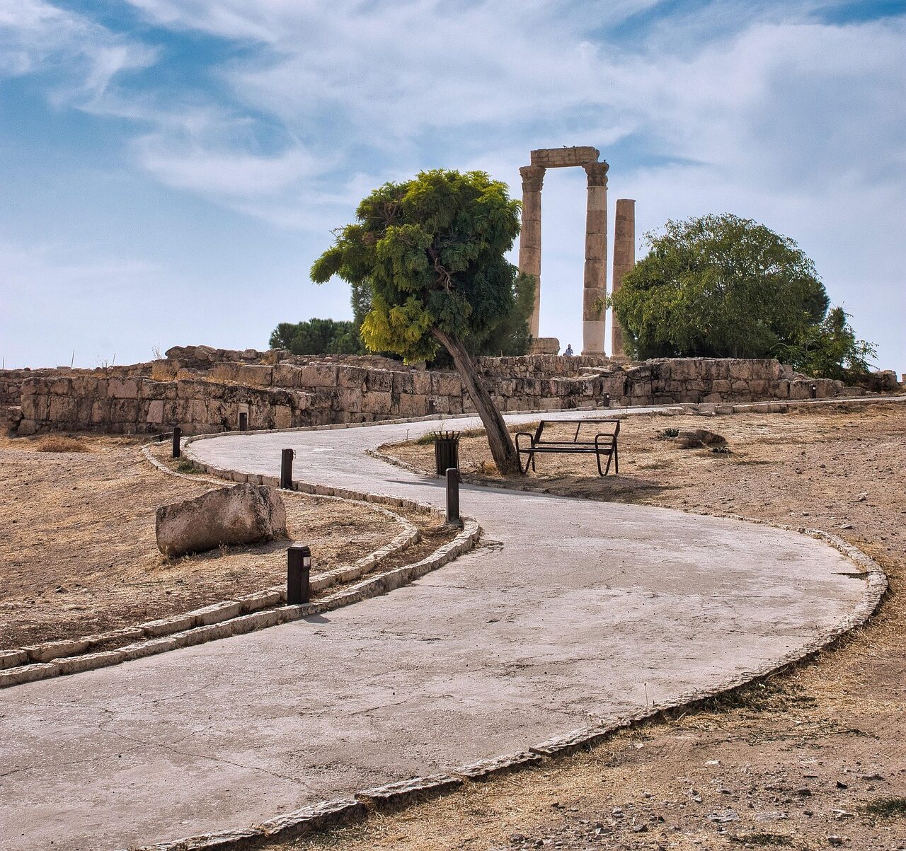Een betegeld pad slingert naar een historisch bouwwerk op een heuvel