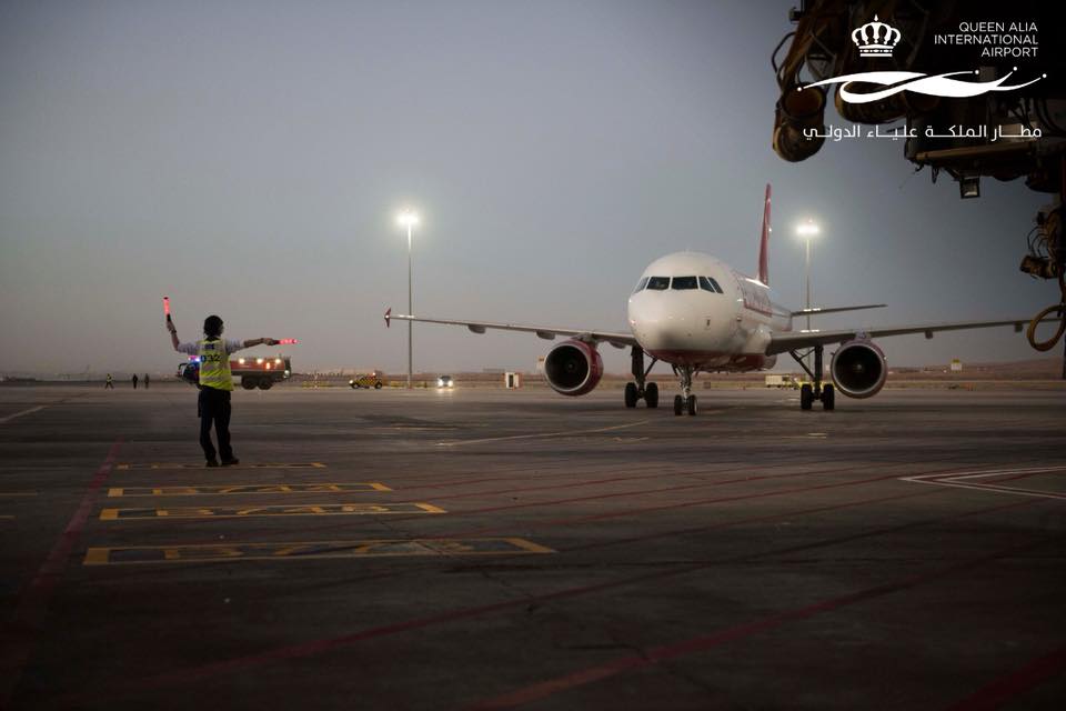 Een loods wijst een vliegtuig naar de plaats aan de slurf op de luchthaven