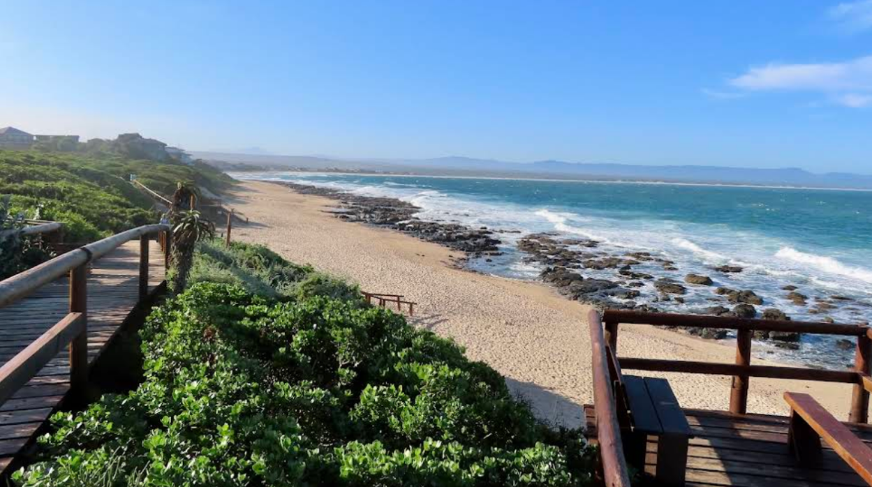 Een uitkijkplatform en houten wandelpad aan een strand bij een zee