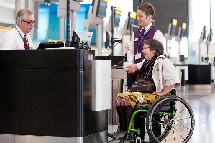 wheelchair information desk with an attendant and 2 tourists of which one in a wheelchair